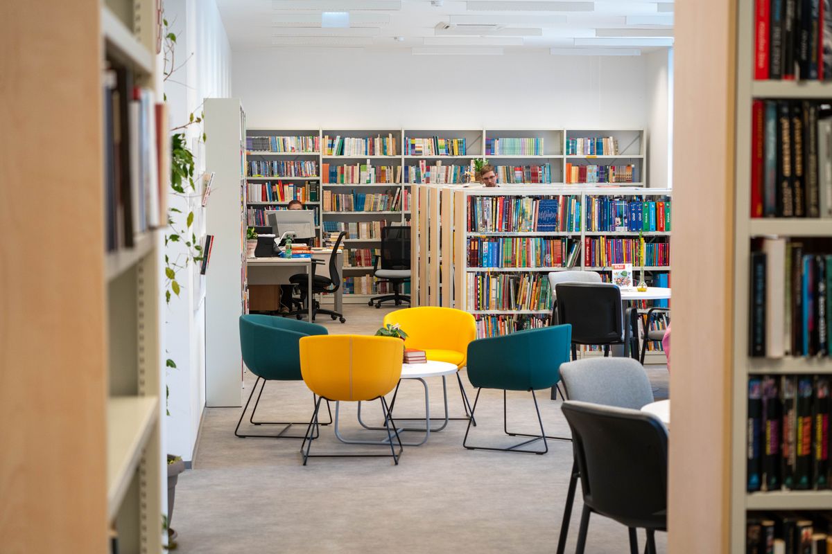 A bright library with colourful seating, reading tables and bookshelves